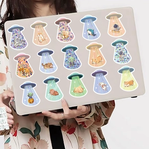 Detailed stickers showing cartoon UFO abductions on a silver grey laptop lid