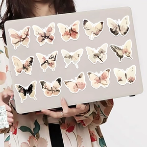 Detalle de 15 pegatinas de mariposas estilo pintura de tinta en un ordenador portátil
