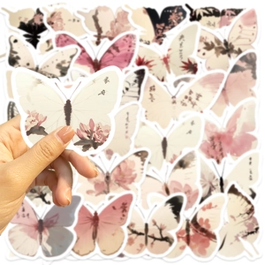 Detalle de pegatinas de mariposas con motivos florales y caligrafía artística de tinta