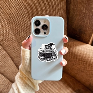 Λεπτομέρεια ματ μπλε θήκης iPhone με ασπρόμαυρα γοτθικά αυτοκόλλητα με κρανία και σκελετούς