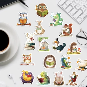 Flat lay of watercolor animal stickers reading books on desk with laptop and coffee