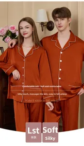 Close-up of rust red silk pajamas with white piping and classic lapel design