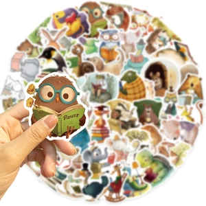 Close-up of owl reading book sticker with waterproof matte finish on blurred background