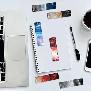 Flat lay of celestial planet bookmarks with laptop and coffee for a cozy study scene