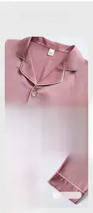 Detail view of lotus pink silk pajamas featuring contrast piping on V-neck and pockets