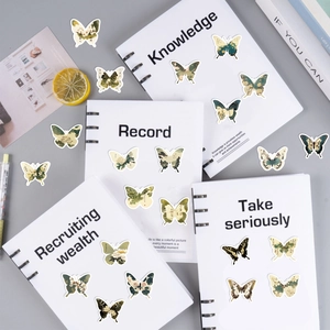 Primer plano de pegatinas de mariposas estilo tinta con motivos florales en cuadernos