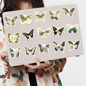 Detalle de 15 pegatinas de mariposas de pintura a la tinta aplicadas en una laptop