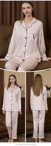 Close-up of pink striped silk pajamas with black piping and embroidered chest pocket