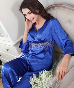 Detail of dark blue silk pajamas featuring elegant purple floral embroidery on the waist