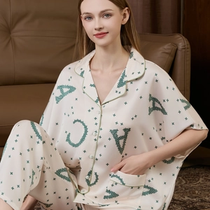 Women's silk pajama set with batwing sleeves, star print shirt and pants in cream and green