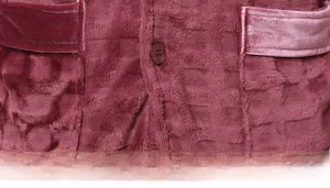 Macro detail of wine red flannel lounge wear featuring square texture and buttoned pockets