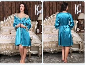 Détail d'un pyjama en satin sarcelle avec bordure en dentelle sur le peignoir et la robe