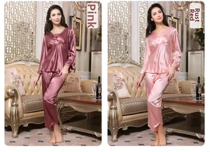 Close-up of rust red and pink silk satin pajamas with V-neckline and pleated detail