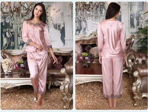 Detail of pink satin pajama set with purple lace trim and long sleeves for women