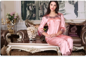 Detailed view of the delicate lace trim on pink satin long-sleeve pajamas set