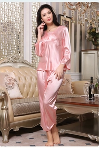 Detailed close-up of pink satin pajama set with elegant lace V-neckline and smooth finish
