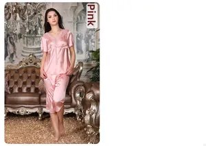 Détail d'un pyjama en satin rose avec col en V en dentelle et cordon de serrage doux