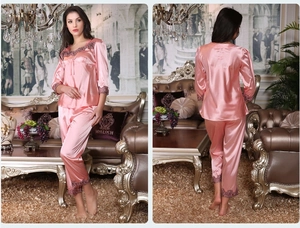 Women's pink silk satin pajamas with intricate lace trim on cuffs and hem, detail view