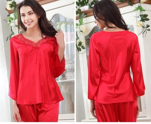 Detail eines roten Seiden-Pyjama-Sets mit Spitzen-V-Ausschnitt und Schleife am Oberteil