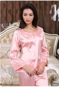 Détail du pyjama en satin rose avec broderie en dentelle et poignets plissés élégants