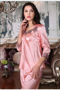 Detailed view of pink satin pajama set with intricate lace trim and ribbon bow detail