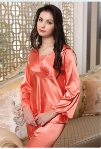 Detailed view of luxury coral silk pajama set with delicate lace trim on the V-neckline