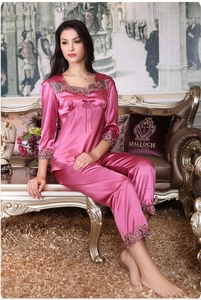 Detail of luxurious lace embroidery and silky satin texture on dark pink pajama sleeve