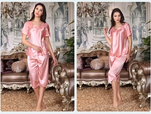 Détail d'un pyjama en satin rose avec bordures en dentelle et nœuds décoratifs