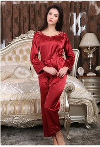 Détail du pyjama en soie rouge avec broderie florale blanche au col et ceinture nouée