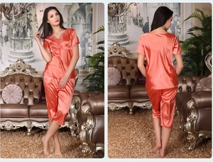 Détail de pyjama en satin corail avec col en V en dentelle et cordon de serrage