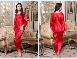 Detail of red silk satin pajamas featuring elegant lace V-neck and high-gloss finish
