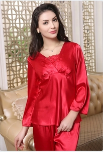 Detail of red satin pajama set featuring V-neck lace trim and silky fabric texture