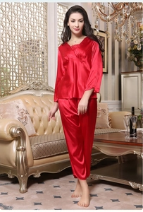 Detail of red satin pajamas showing the glossy silk-like texture and front pleated design