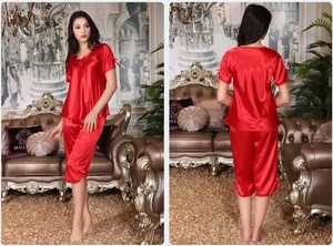 Détail d'un pyjama en satin rouge avec manches courtes, pantalon court et nœuds