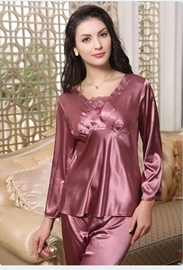 Detail of pink satin pajama set featuring delicate lace trim on the V-neck and sleeves