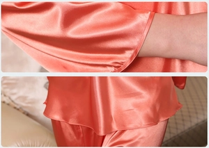 Detail showing the glossy coral satin fabric texture and premium sewing of the pajamas