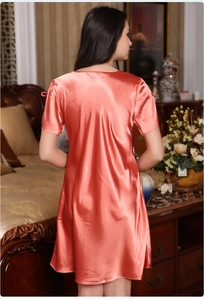 Detail of coral orange satin nightdress showing smooth silk texture and sheen