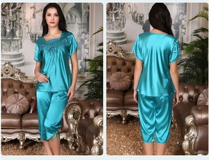 Detail of teal satin pajama set with lace neckline embroidery and decorative bow ties