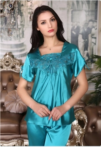 Detail of silk pajamas featuring lace square neck with bow and satin sheen finish