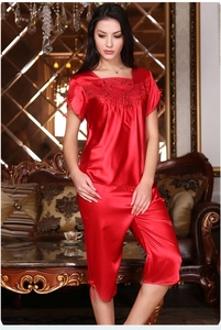Detail showing red satin pajamas with delicate lace embroidery and bow accents on sleeve
