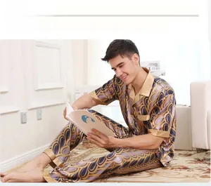 Detail of luxury silk-like men's pajama set with blue gold peacock pattern and notch lapel