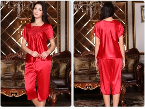 Detail of red silk pajama set with lace embroidery and bow accents on sleeves