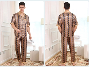 Detail of silk-like satin men's pajamas set featuring gold paisley patterns on navy blue