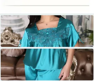 Detail of silk satin pajamas featuring square neckline and intricate lace embroidery