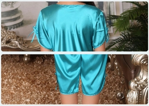 Detail of silk satin pajamas set with bow knots on sleeves and shorts in green color