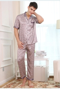 Close-up of men's satin pajama set with fine leaf patterns and purple piping detail