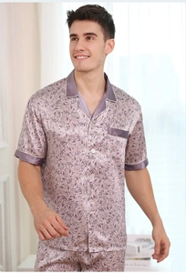 Close-up of men's purple satin pajama set featuring tropical leaf print and white piping