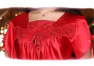 Detail of red satin pajamas with delicate lace embroidery and silk ribbon bow