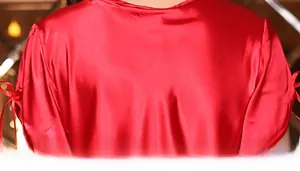 Detailed view of red silk pajama top featuring satin luster and bow-knot sleeve design