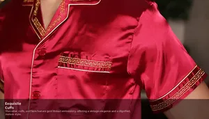 Detail of dark red satin pajama top with gold embroidery on the collar and pocket